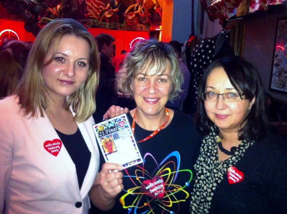 Kamila, Magda and Joanna at the Polish Global Village Happy Hour in Alexandria, Virginia, wearing red heart logo stickers from the Great Orchestra of Christmas Charity